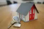 des clés et une maison miniature rouge