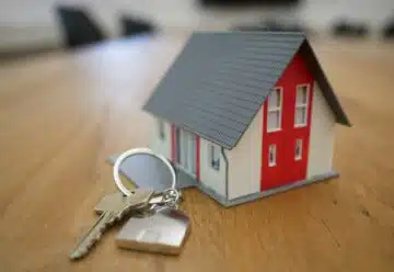 des clés et une maison miniature rouge